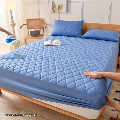 Waterproof blue mattress protector cover on bed, ultra-soft and quilted for comfort and protection.