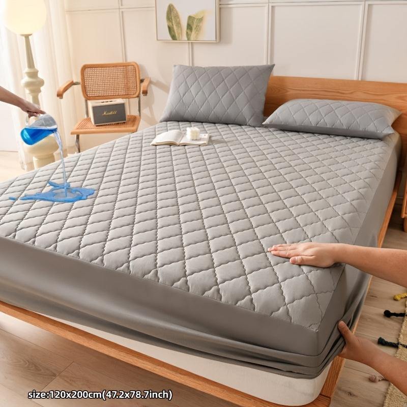 Waterproof mattress protector cover in gray, ultra-soft quilted polyester, shown with liquid resistance.